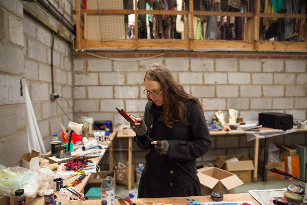 Claire in the art department area giving the Kah'Nath arrows a lick of paint.