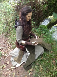 Sophie Skelton (Ren) kneels beside the river in prepation for a scene with Karn.